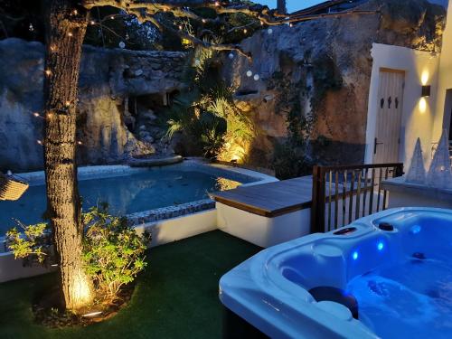 a jacuzzi tub in a garden with a tree at Casa Louise Suites and Spas privatifs in Sainte-Maxime