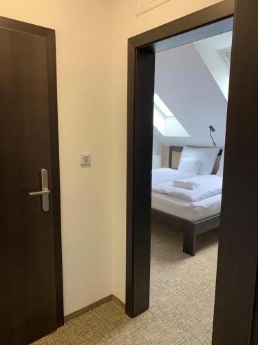 a door leading to a bedroom with a bed at Penzion U Broucka in Milevsko