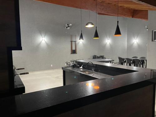 a kitchen with a counter top and a dining room at Casa De Temporada Eldorado in Olímpia