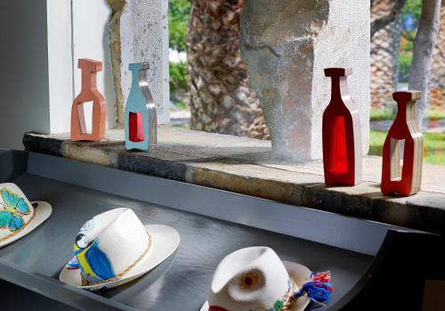 a shelf with bottles and hats on a window sill at St. Nicolas Bay Resort Hotel & Villas in Agios Nikolaos