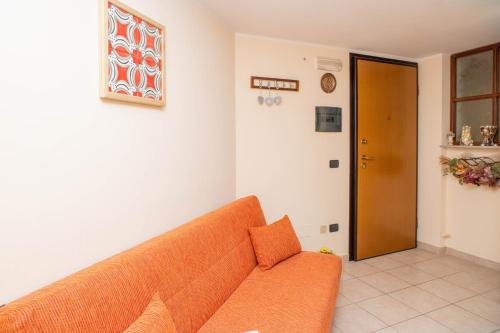 an orange couch in a living room with a door at Contaldi House in Nocera Superiore