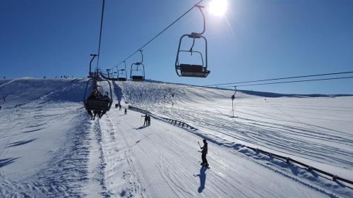 a group of people skiing down a snow covered ski lift at Wellness Chalet Bell a Mur in Murau
