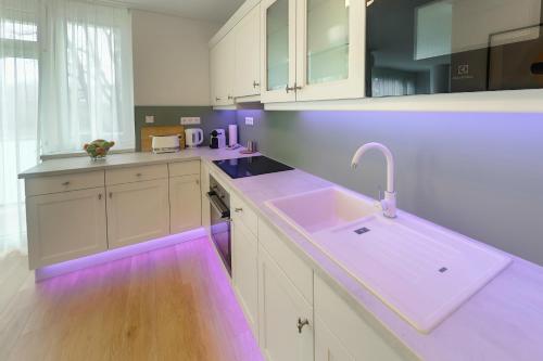 a kitchen with purple lighting on the counters at Hip riverview bestern in Szeged