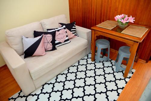 a living room with a couch with pillows and a table at Studio Reformado e Completo em área nobre do Flamengo! in Rio de Janeiro