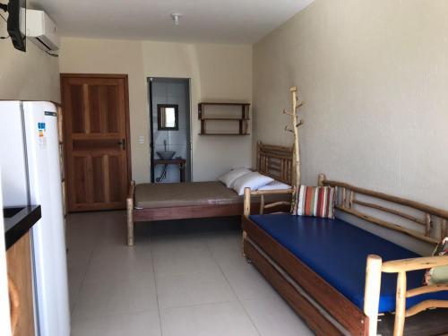 a small room with two beds and a refrigerator at Residencial Berê in Palhoça