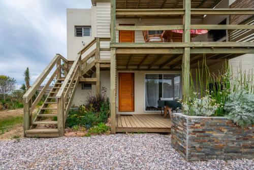 a house with a wooden deck and a staircase at Alma Serena in La Paloma