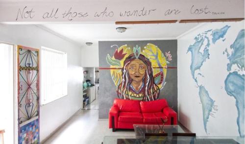 a living room with a red couch and a mural at Belem Hostel in Belém