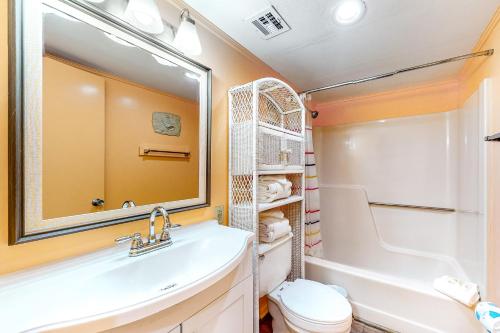 W łazience znajduje się umywalka, toaleta i lustro. w obiekcie Gulf Shores Plantation #1262 w mieście Gulf Shores