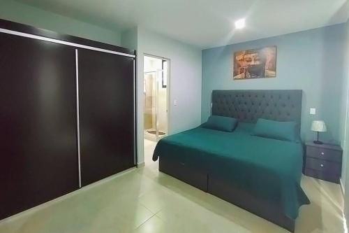 Un dormitorio con una cama azul y una puerta de cristal en Sukha Condo, the coziest place to stay in Playa, en Playa del Carmen