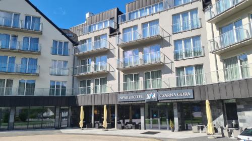 a large white building with a sign on it at Aparthotel Apartamenty Czarna Góra 340 in Sienna