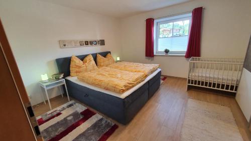 a bedroom with a bed and a window and a crib at Apart4You Ötztal in Sautens