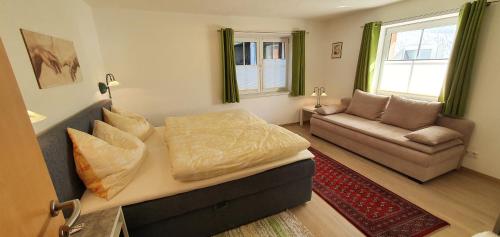 a living room with a bed and a couch at Apart4You Ötztal in Sautens