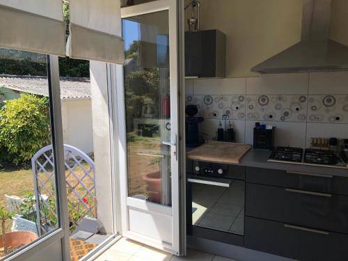 a kitchen with a stove top oven next to a window at APPARTEMENT CONLEAU VANNES une Chambre WIFI in Vannes