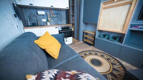 uma sala de estar com um sofá azul com uma almofada amarela em Cosy - Appartement 2 personnes - Tignes le Lac - 415 - Le Palafour em Tignes
