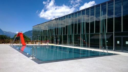uma piscina em frente a um edifício de vidro em Hotel Val Joly em Saint-Gervais-les-Bains
