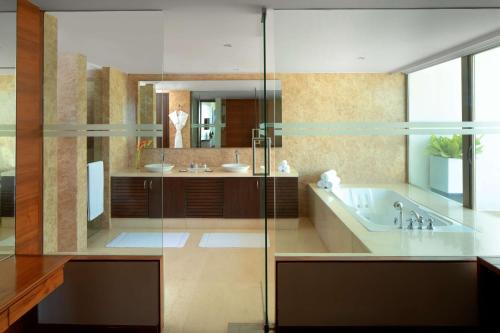 a bathroom with a tub and a sink and a mirror at Radisson Blu Plaza Hotel Hyderabad Banjara Hills in Hyderabad