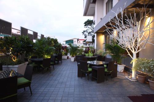 an outdoor patio with tables and chairs and plants at Radisson Blu Plaza Hotel Hyderabad Banjara Hills in Hyderabad