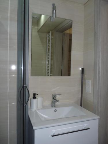 een badkamer met een wastafel en een spiegel bij Apartament w centrum Ciechocinka in Ciechocinek