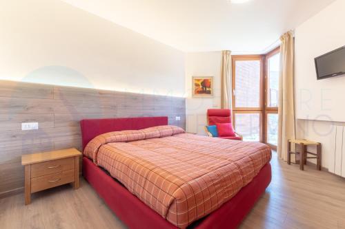 1 dormitorio con cama roja y silla roja en Monte Cervino apartment AS1, en Breuil-Cervinia