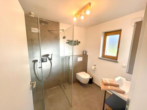 La salle de bains est pourvue d'une douche, de toilettes et d'un lavabo. dans l'établissement Sweet Home Apartment Ammersee - eco-friendly, Boxspring, Garden, WiFi, à Inning am Ammersee