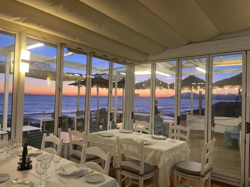 un restaurante con mesas y sillas y vistas al océano en Romana Playa Marbella, en Marbella