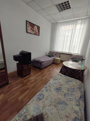 a living room with a bed and a piano at Отель Меридиан in Zolotonosha