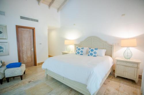 a bedroom with a large white bed with blue pillows at Xeliter Balcones del Atlantico - Las Terrenas in Las Terrenas