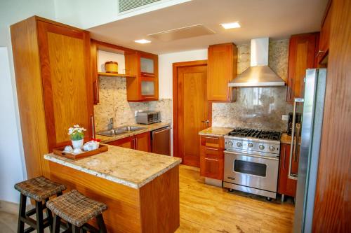 a kitchen with wooden cabinets and a stove top oven at Xeliter Balcones del Atlantico - Las Terrenas in Las Terrenas