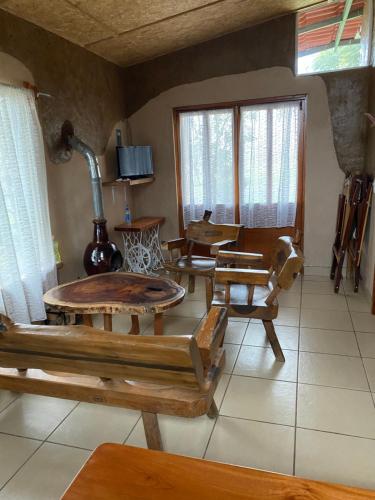 a living room with wooden tables and chairs at Cabañas Los Abuelos in Zacatlán