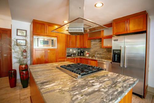 a kitchen with a granite counter top and stainless steel appliances at Xeliter Balcones del Atlantico - Las Terrenas in Las Terrenas