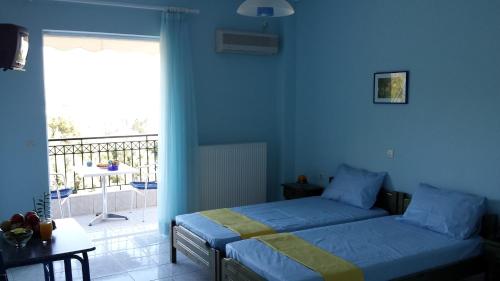 a blue bedroom with a bed and a balcony at Natura Studios in Loutra Edipsou