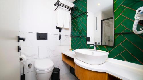 a bathroom with a sink and a toilet at Leaf Port Hotel in Antalya