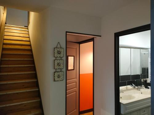 a bathroom with a staircase and a sink and a mirror at LE BIEn Zen in Lebiez