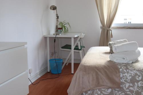 a bedroom with a bed and a desk and a table at Chez Jacqueline in Lisbon