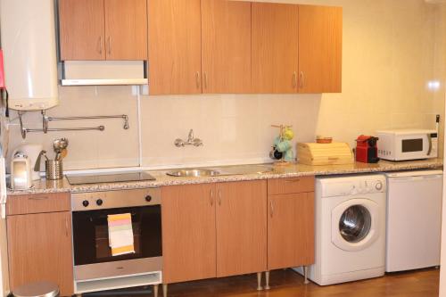 a kitchen with a sink and a washing machine at Chez Jacqueline in Lisbon