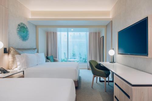 a hotel room with a large bed and a television at Vignette Collection SOUMA Hotel by IHG in Lima