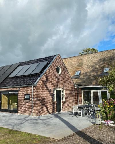 a brick house with solar panels on the roof at Benbijdokkum in Driesum
