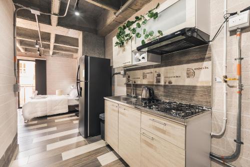 a kitchen with a black refrigerator and a sink at Magenta Loft in Medellín