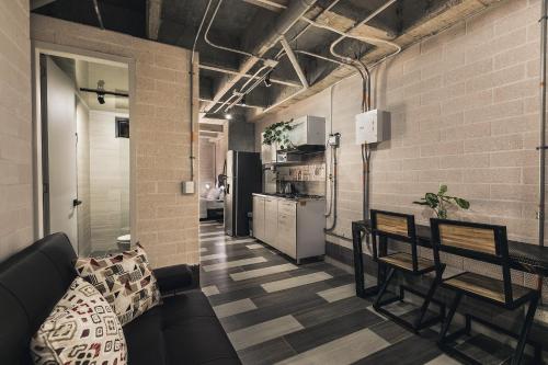 a living room with a couch and chairs and a kitchen at Magenta Loft in Medellín