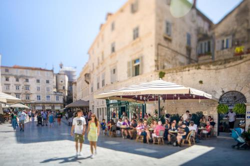 a group of people walking down a city street at Judita Palace Heritage Hotel in Split