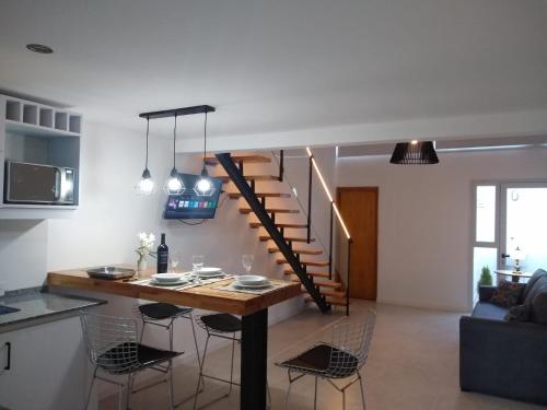 a kitchen and living room with a table and a staircase at Athuel loft in Ostende