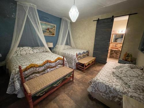 a bedroom with two beds and a chandelier at La Casona Azul Boutique Hotel in Malinalco