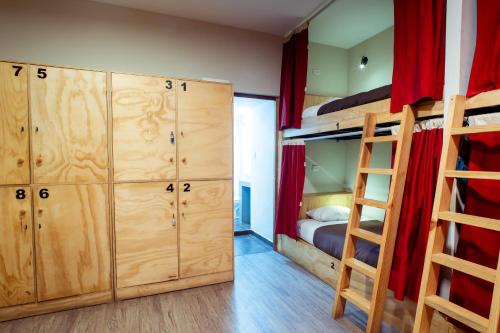
a wooden bunk bed in a small room at Kokopelli Hostel Cusco in Cusco
