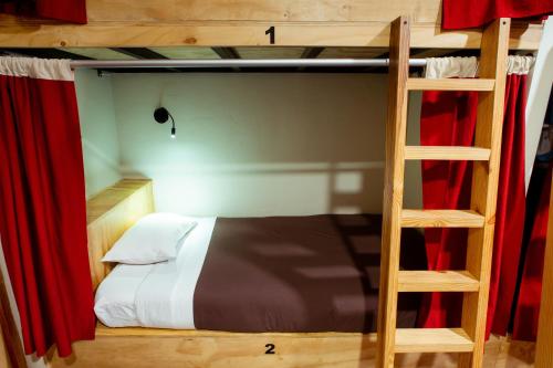 a bunk bed in a room with a wooden wall at Kokopelli Hostel Cusco in Cusco