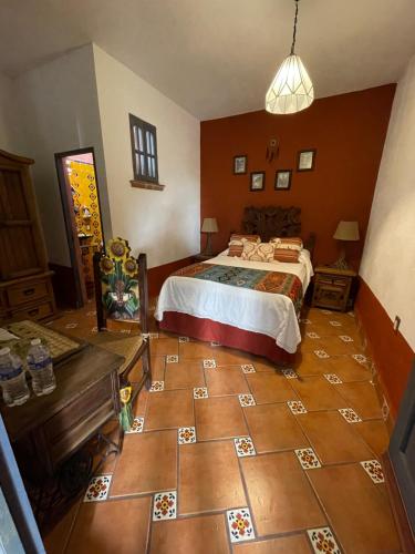 a bedroom with a bed and a tiled floor at La Casona Azul Boutique Hotel in Malinalco