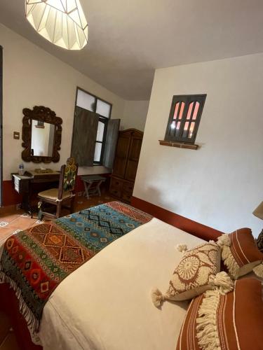 a bedroom with a large bed and a mirror at La Casona Azul Boutique Hotel in Malinalco