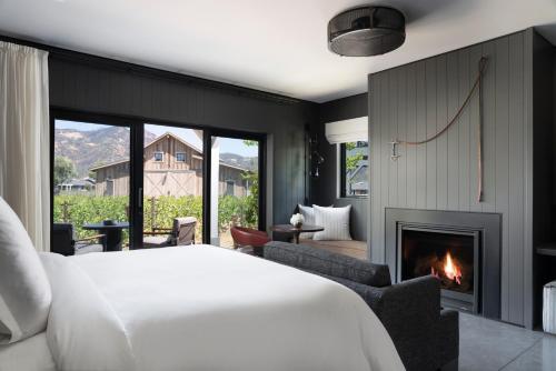Four Seasons Resort Napa Valley في كاليستوغا: غرفة نوم بسرير ومدفأة
