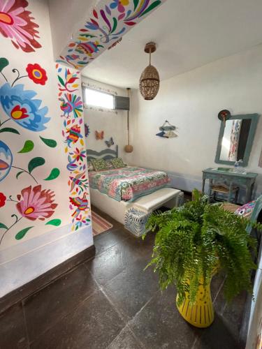 a room with a bed and a flowery wall at La Casona Azul Boutique Hotel in Malinalco