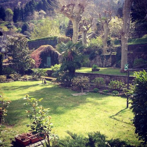 a garden with a yard with grass and trees at Hotel Trieste in Morbegno