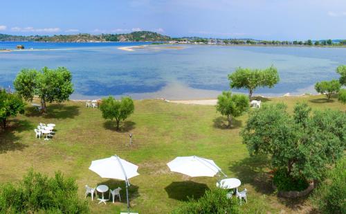 a view of a beach with tables and umbrellas at Livari Studios in Vourvourou